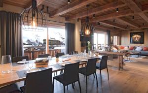 a dining room with a long table and chairs at Odalys Chalet Le Lys in Les Deux Alpes