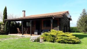 a log cabin with a table and chairs in a yard at La Casa del Carballo in Pisones