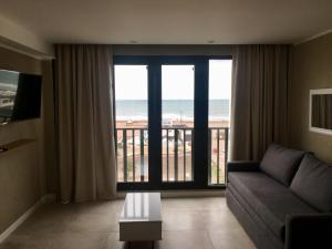 a living room with a couch and a view of the ocean at Michelle- Departamentos in Necochea