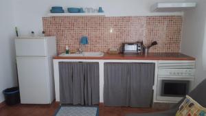uma cozinha com um frigorífico branco e um lavatório em Casas Baro2 em Zahora