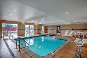una gran piscina con sillas y una mesa en Comfort Suites Foley - North Gulf Shores, en Foley