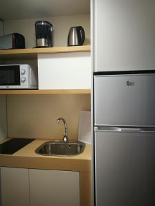 a kitchen with a stainless steel refrigerator and a sink at Bungalows Vistalmar in San Agustin