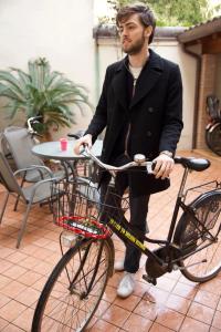 Ein Mann im Anzug, der auf einem Fahrrad sitzt. in der Unterkunft Guest House Delizia Estense in Ferrara