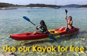 two women are sitting in a kayak in the water at Villa Strp in Risan