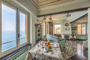 jadalnia ze stołem i dużymi oknami w obiekcie CASA CONSTANZA Pace e Relax in Liguria w mieście Camogli