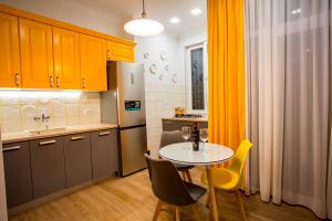 a small kitchen with a table and yellow chairs at Yellow apartment in Avlabari in Tbilisi City