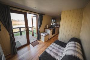 a living room with a couch and a sliding glass door at Avon Riverside Glamping in Warwick