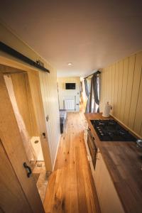 a kitchen with wooden floors and a stove top oven at Avon Riverside Glamping in Warwick
