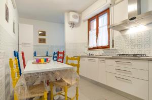 una cucina con tavolo e alcune sedie gialle di Casa Vacanza Flora a Sperlonga
