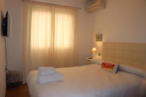 a bedroom with a white bed with towels on it at Villa Sa Vinyeta in Sant Llorenç de Balafia +41 photos