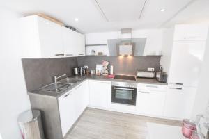 a white kitchen with white cabinets and a sink at Perfect Apartment near Opera in Bayreuth