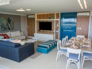 uma sala de estar com uma mesa e um sofá em Céu Estrelado: Cobertura Premium no Golf Ville em Aquiraz