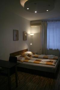 a bedroom with a large bed with a desk and a window at Margaret Bridge Studio Apartment in Budapest