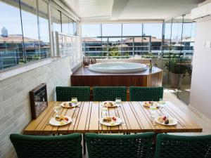 uma sala de jantar com uma mesa e cadeiras e uma banheira em Céu Estrelado: Cobertura Premium no Golf Ville em Aquiraz