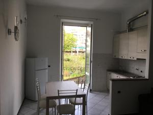 eine Küche mit einem Tisch und Stühlen sowie einem Fenster in der Unterkunft STATION'S WINDOWS in La Spezia