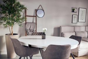 een witte eetkamer met een witte tafel en stoelen bij HUISJES AAN DE AMSTEL - Your home away from home in Amstelveen