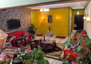 uma sala de estar com mobiliário vermelho e uma parede amarela em Luxury Apartment City stars em Cairo