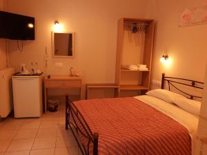 キパリシアにあるHotel Trifyliaのベッドルーム1室(ベッド1台付)、バスルーム(シンク付)