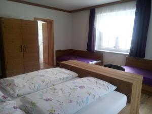 1 dormitorio con 2 camas y ventana en Ferienhaus Mendlingbauer, en Lassing