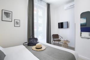 una habitación de hotel con una cama con sombrero en Hôtel Alcôve Nice, en Niza