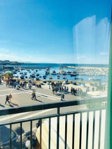 a group of people walking on a sidewalk near a harbor at Torre a mare Sun in Torre a Mare