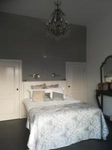 a bedroom with a large white bed with a chandelier at Bed & Breakfast Diemerbrug in Amsterdam