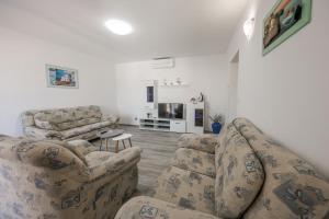 - un salon avec deux canapés et une télévision dans l'établissement Apartment Tragurion, à Trogir