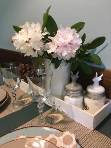 a table with glasses and flowers in a tray at Decor Park Apartament in Karpacz