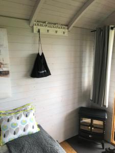sypialnia z łóżkiem i czarną torbą na ścianie w obiekcie The Cherry Tree Gypsy Wagon w mieście Banbury