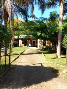 a driveway leading to a house with palm trees at QUINTA EN OPEN DOOR-LUJÁN in Luján