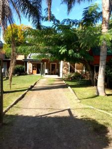 a walkway in front of a house with palm trees at QUINTA EN OPEN DOOR-LUJÁN in Luján