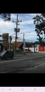 un coche conduciendo por una calle de la ciudad con un McDonalds en Blissful Hill Tagaytay Condotel with Netflix en Tagaytay