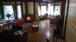 a living room with couches and chairs and a fireplace at Chalé Martinho in Gramado