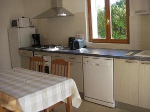 cocina con mesa, fregadero y nevera en Les 4 Saisons en Sarlat-la-Canéda