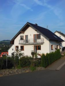 una casa blanca con techo negro en Ferienwohnung Basche, en Oberzissen