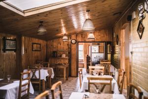 a restaurant with wooden walls and tables and chairs at Hostal Alcázar in Puerto Natales