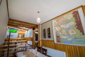 a restaurant with tables and a large map on the wall at Hostal Alcázar in Puerto Natales