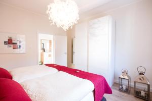 a bedroom with a white bed and a chandelier at Glockenstuhl @Conny's in Brilon