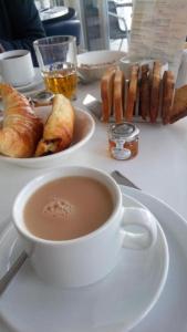 a table topped with a plate of food and a cup of coffee at Legends Hotel in Brighton & Hove