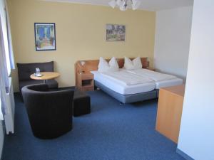 Schlafzimmer mit einem Bett, einem Tisch und Stühlen in der Unterkunft Hotel Am Weyerhof in Kerpen