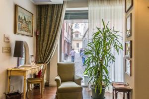 a living room with a window and a chair and a plant at Hotel Torino in Parma