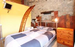 a bedroom with a large bed and a stone wall at La Calma de Bellver in Bellver de Cerdanya  +58 photos