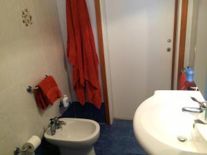 un bagno con un water bianco e un lavandino di Appartamento Torre Pali a Torre Pali