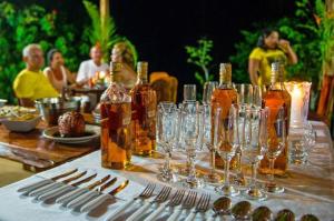 a table with wine bottles and wine glasses on it at Aldeia Mari-Mari Amazon Lodge in Presidente Figueiredo