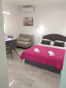 a bedroom with a large bed with a pink blanket at Apartment Golden Dreams in Podstrana