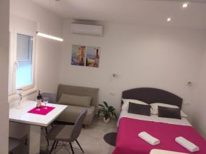 a bedroom with a bed and a table and a couch at Apartment Golden Dreams in Podstrana