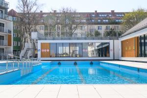 a swimming pool with blue water in a building at Apartamenty Nadmorskie in Kołobrzeg