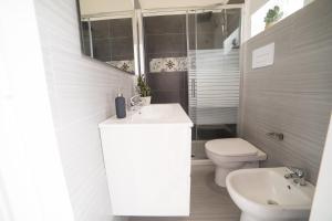 a white bathroom with a sink and a toilet at Peschici HOME FILOCCO stanza e bagno privato in Peschici