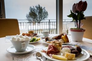 una mesa con platos de comida y tazas de café en Hotel Orizzonte en Bellaria-Igea Marina