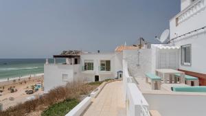 Blick auf den Strand vom Balkon eines Hauses in der Unterkunft Vila Varanda by Sevencollection in Salema